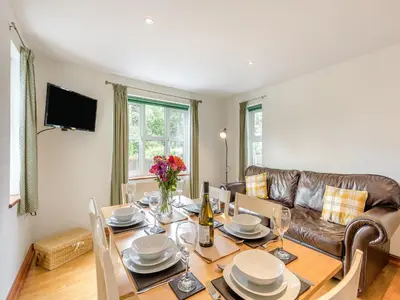a dining room with a table and a couch at Cysgod Y Capel in Cerrigydrudion