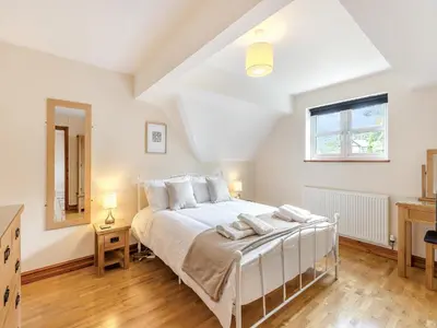 a bedroom with a large white bed and a window at Cysgod Y Capel in Cerrigydrudion