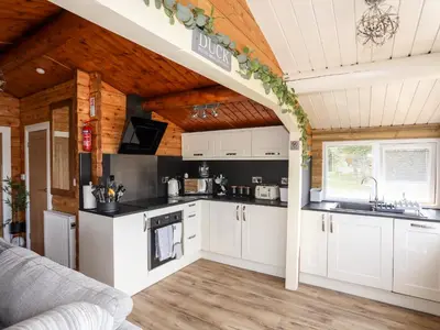 a kitchen with white cabinets and a wooden ceiling at Ty Coed - 63 in Trawsfynydd