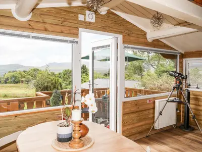 a room with a table and a camera on a balcony at Ty Coed - 63 in Trawsfynydd