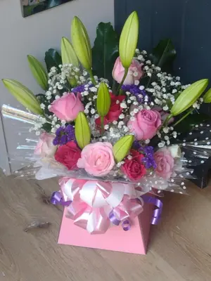 a bouquet of flowers in a box with a note at Shepherd's Watch Cottage - 5* Cyfie Farm with private hot tub in Llanfyllin
