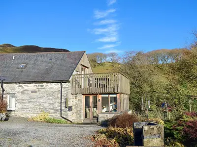 a stone house with a deck on top of it at Penroc in Pentre-briwnant
