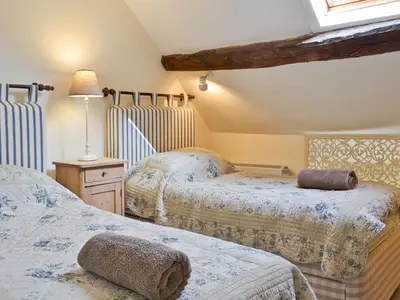 a bedroom with two beds and a table with a lamp at Penroc in Pentre-briwnant
