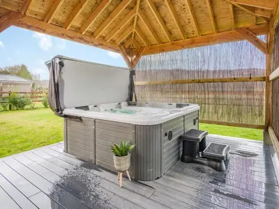 a hot tub on a deck with a wooden roof at Mouse Croft - Uk33954 in Llanymynech
