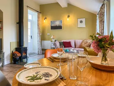 a dining room with a table and a fireplace at The Bothy - Uk33692 in Bicton