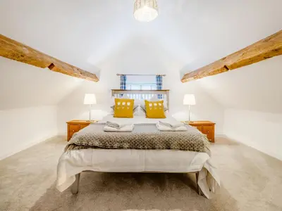 a white bedroom with a large bed with yellow pillows at Pheasants Folly - Uk33955 in Llanymynech