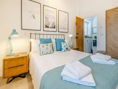a bedroom with a large white bed with blue pillows at Pheasants Folly - Uk33955 in Llanymynech