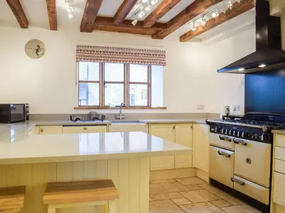 a large kitchen with a large white counter top at Colstey Farmhouse in Acton