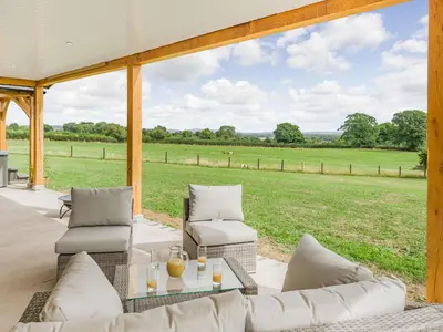 a screened in porch with a couch and two chairs at Oak Tree Lodge - Uk38383 in Lyonshall