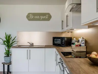a kitchen with white cabinets and a sign that reads be can crust at Bramley Lodge - Uk38384 in Lyonshall