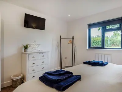a bedroom with a bed with two blue towels on it at Bramley Lodge - Uk38384 in Lyonshall