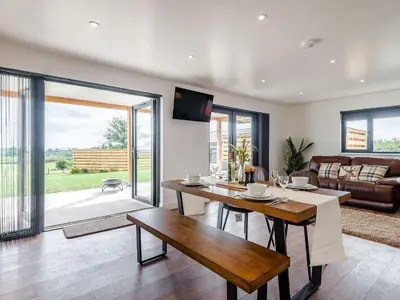 a living room with a table and a couch at Bramley Lodge - Uk38384 in Lyonshall
