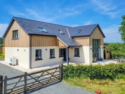 a home with a barn style house with a fence at Red Kite Lodge in Tregaron