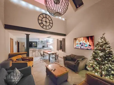 a living room with a christmas tree and a clock at Red Kite Lodge in Tregaron