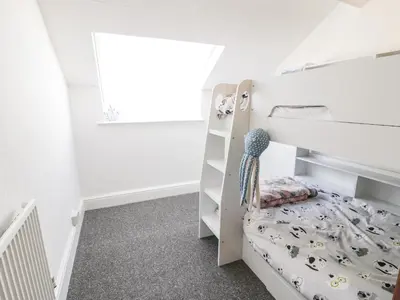a white childs bedroom with a bunk bed at 4A Victoria Place in Barmouth