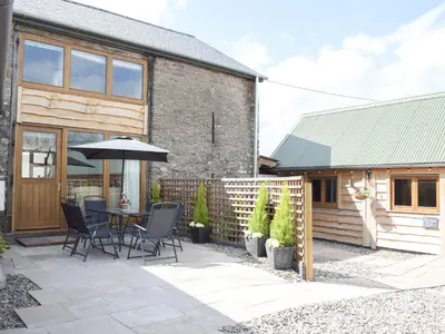 a patio with a table with chairs and an umbrella at Horsecroft - Uk37462 in Dorstone