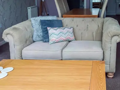 a couch with pillows and a coffee table in a living room at Tyglyn Cottage in Lampeter