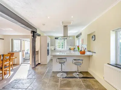a kitchen with a counter and two stools at The Cottage-Uk37339 in Montgomery