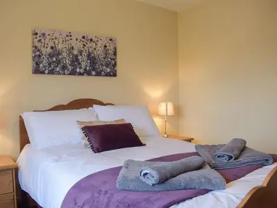a bedroom with a bed with towels on it at The Larches in Hopton Cangeford