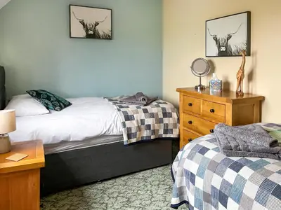 a bedroom with two beds and a dresser at The Larches in Hopton Cangeford