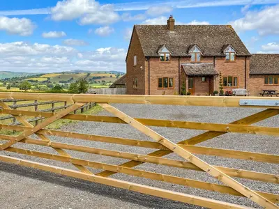 a wooden gate in front of a house at The Larches in Hopton Cangeford
