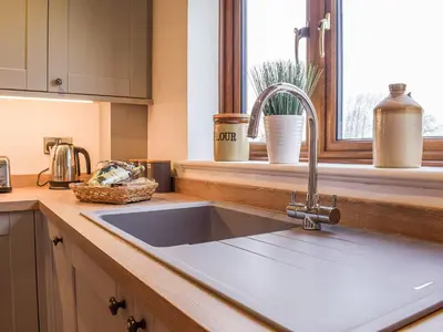 a kitchen counter with a sink and a window at The Larches in Hopton Cangeford