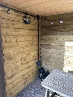 a room with a wooden wall with a picnic table at Mini haven in Oswestry
