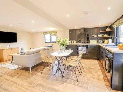 a kitchen and living room with a table and chairs at The Cabin at Evelyns Retreat in Corwen