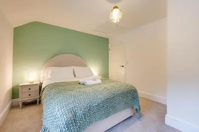 a bedroom with a bed with a green wall at 3 Bed in Machynlleth oc-bow321 in Cemmaes