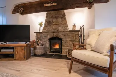 a living room with a stone fireplace and a television at 3 Bed in Machynlleth oc-bow321 in Cemmaes