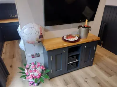 a small blue cabinet with a cake and a balloon at Little Acorn - Luxury shepherd's hut / lodge with private hot tub and garden in Llanfyllin