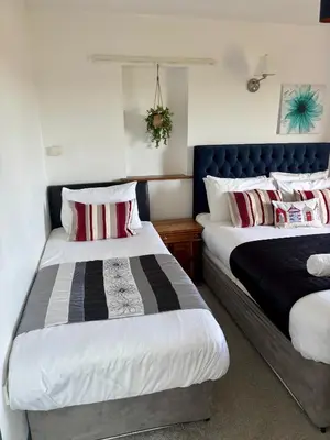 a bedroom with two beds and a blue headboard at The Calf Suite in Aberystwyth