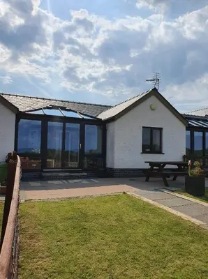 a house with a picnic table in front of it at The Calf Suite in Aberystwyth