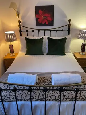 a bedroom with a large bed with two lamps at The Calf Suite in Aberystwyth