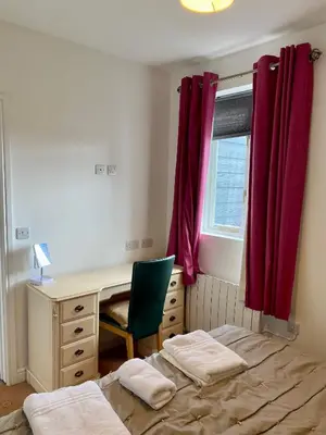 a bedroom with a bed and a desk and a window at Ty Bach in Aberystwyth