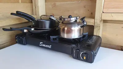 a tea kettle and pans on top of a stove at Calon Y Goedwig Glamping in Llandovery
