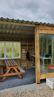 a wooden cabin with a picnic table in front of it at Calon Y Goedwig Glamping in Llandovery