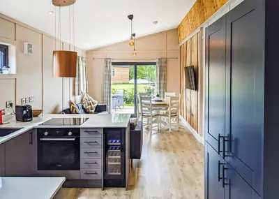 a kitchen with a counter and a dining room at The Warrens At Foxtail in Chirk