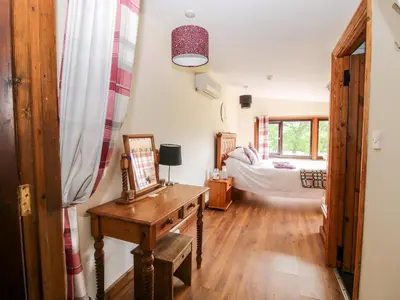 a living room with a table and a bedroom at The Retreat in Oswestry