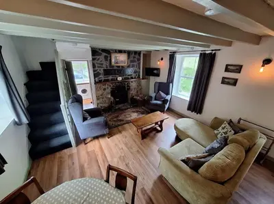 a living room with two couches and a fireplace at Cosy riverside cottage in beautiful Corris in Corris