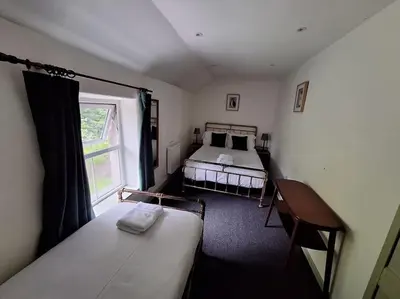 a bedroom with a bed and a window at Cosy riverside cottage in beautiful Corris in Corris