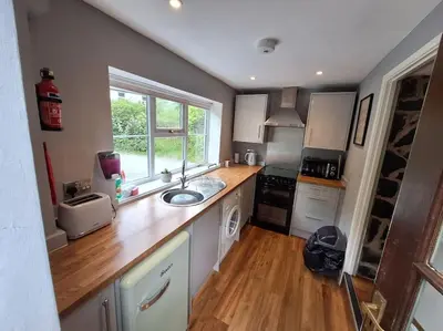 a kitchen with a counter and a sink and a window at Cosy riverside cottage in beautiful Corris in Corris