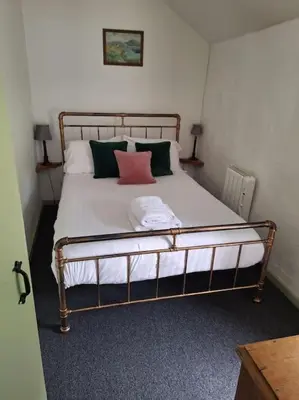 a bed with two pillows on it in a room at Cosy riverside cottage in beautiful Corris in Corris