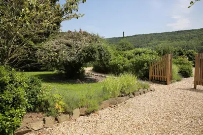 a garden with a wooden fence and some bushes at Woodpecker Way at Eaton Manor in Eaton