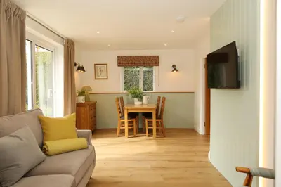 a living room with a couch and a table at Woodpecker Way at Eaton Manor in Eaton