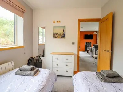 a bedroom with two beds and a mirror at Bryn Hyfryd in Talsarnau