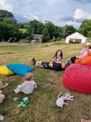 a group of people sitting in the grass at MotoCamp Wales - Lodges in Dolgellau