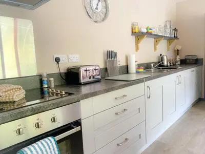 a kitchen with white cabinets and a counter top at MotoCamp Wales - Lodges in Dolgellau