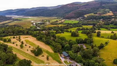 an aerial view of a farm with mountains in the background at MotoCamp Wales - Lodges in Dolgellau