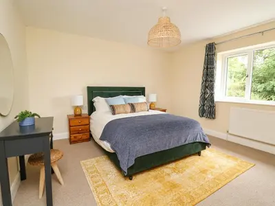 a bedroom with a bed and a desk and a window at Ty Ni in New Quay